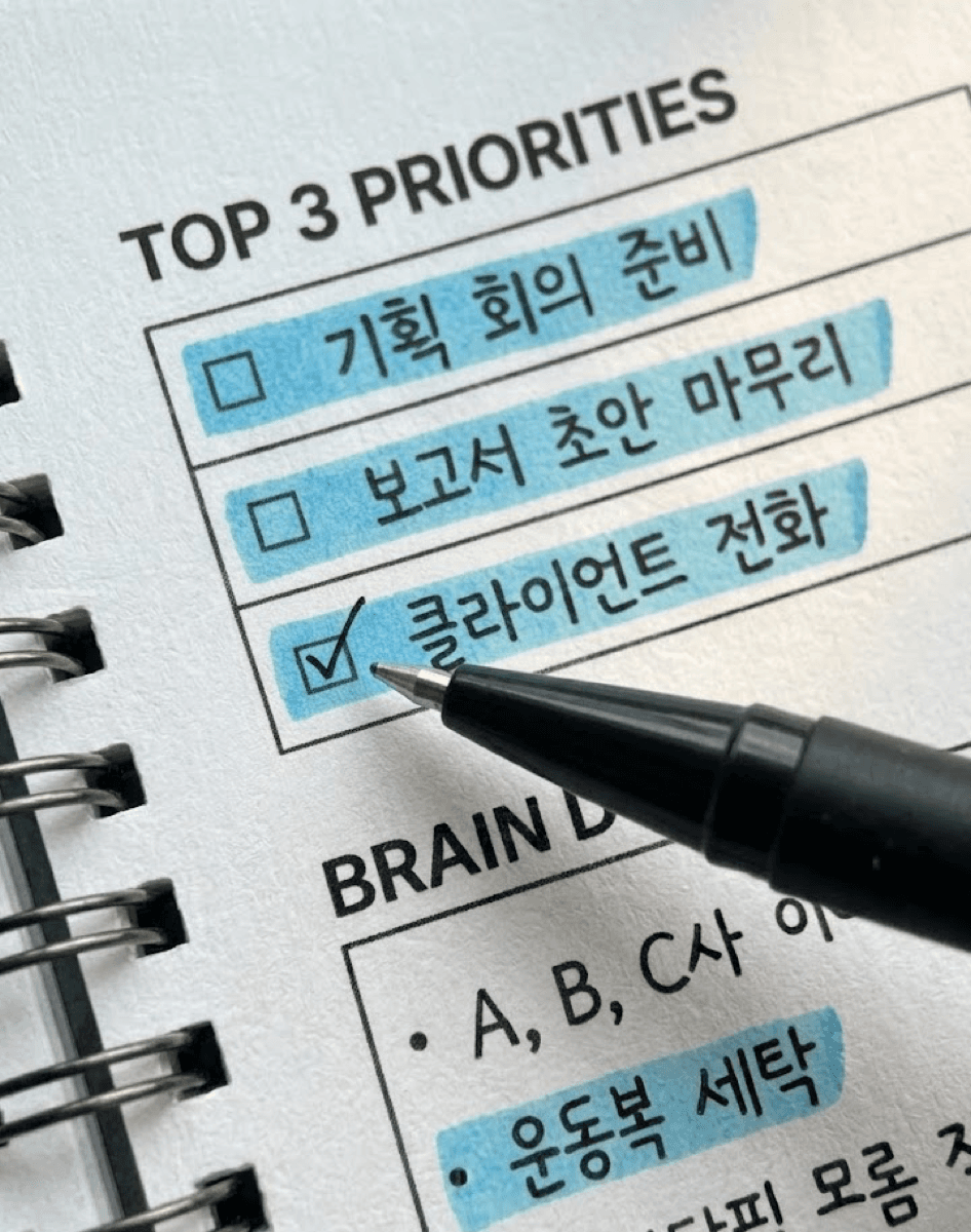 종이 플래너의 TOP 3 PRIORITIES 칸에 형광펜을 칠하는 모습